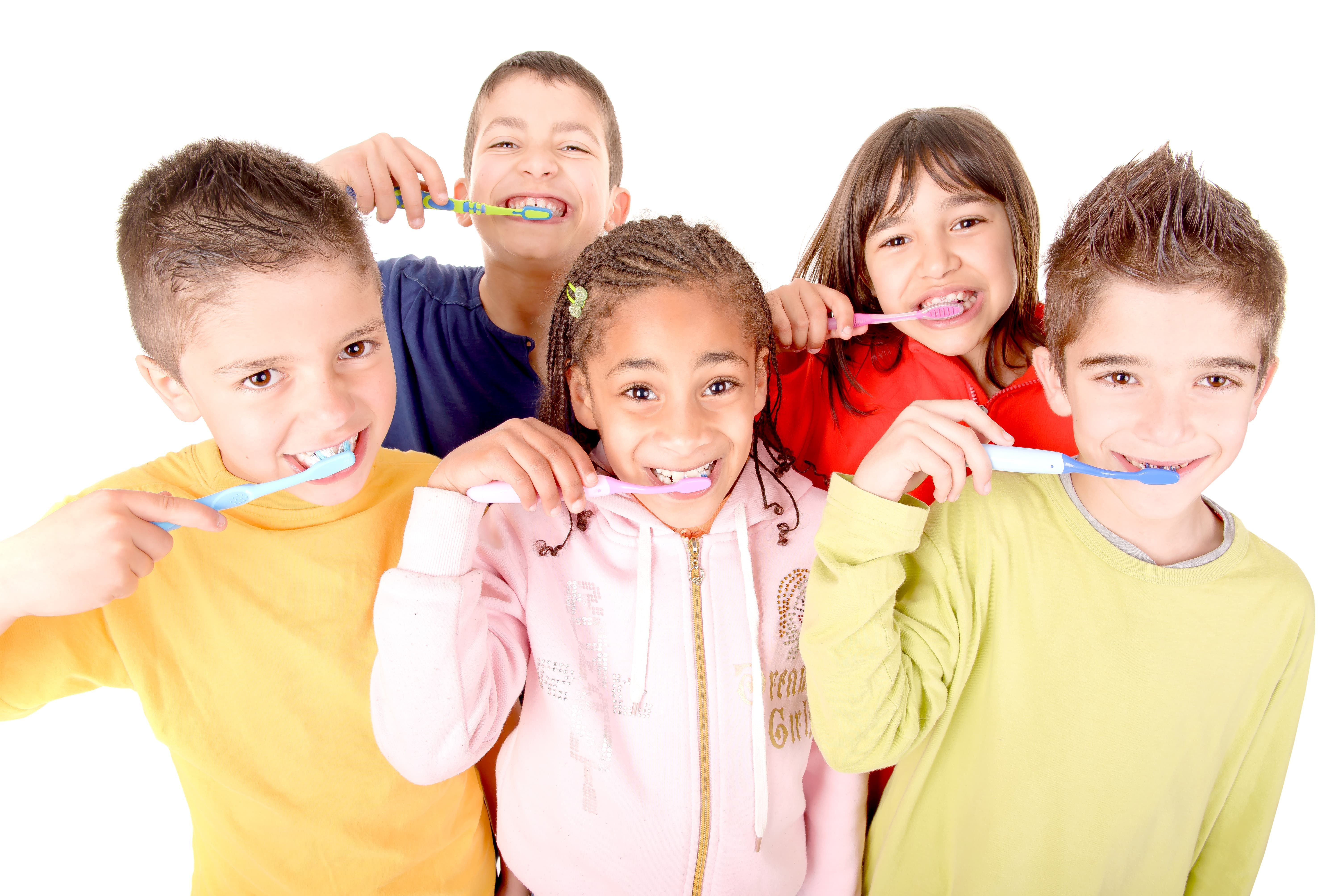 A group of five kids brushing their teeth