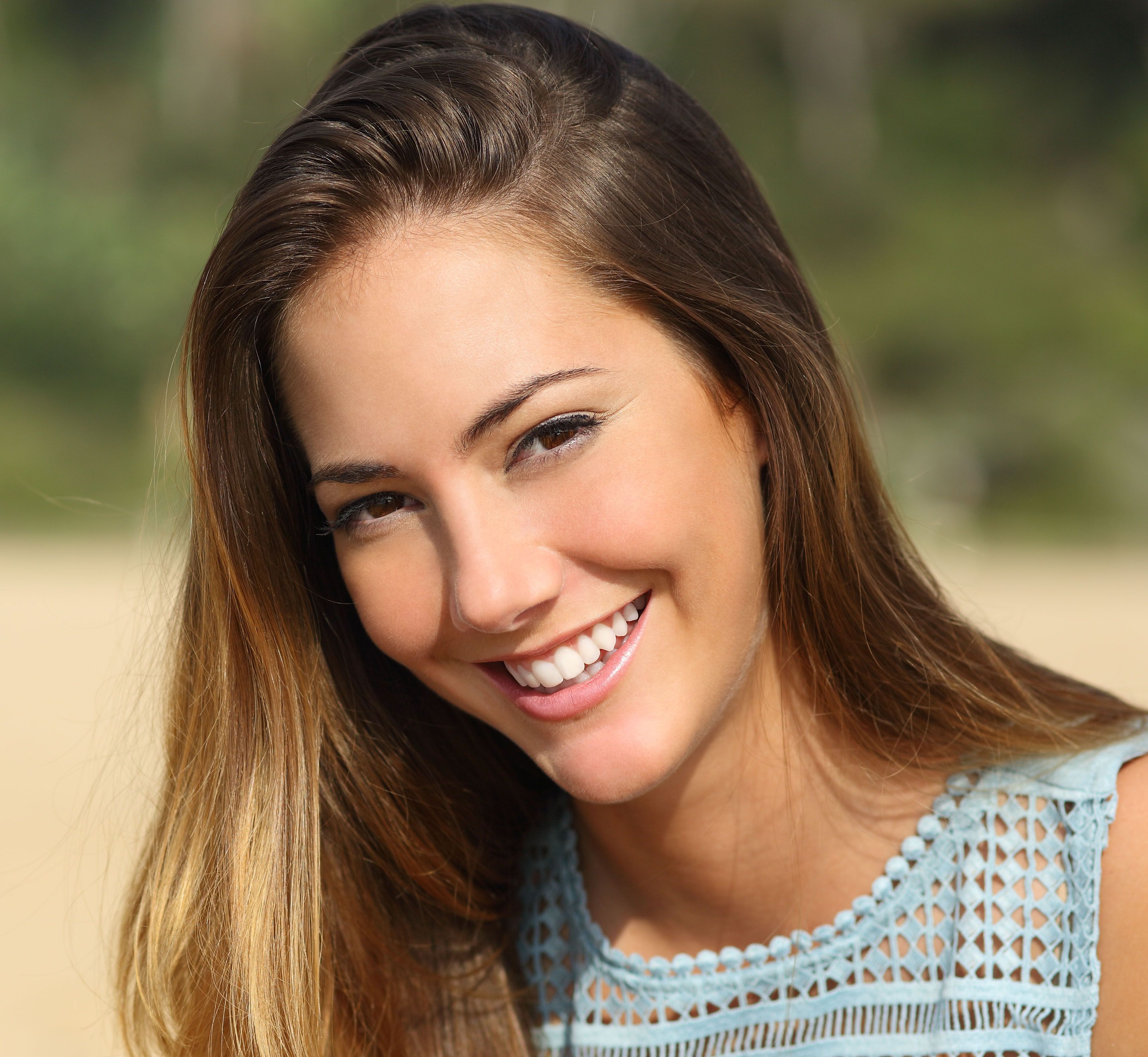 Portrait of a woman with a white teeth and perfect smile outdoors