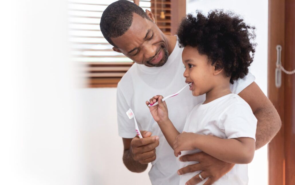 Father Caring For Daughter's Dental Health