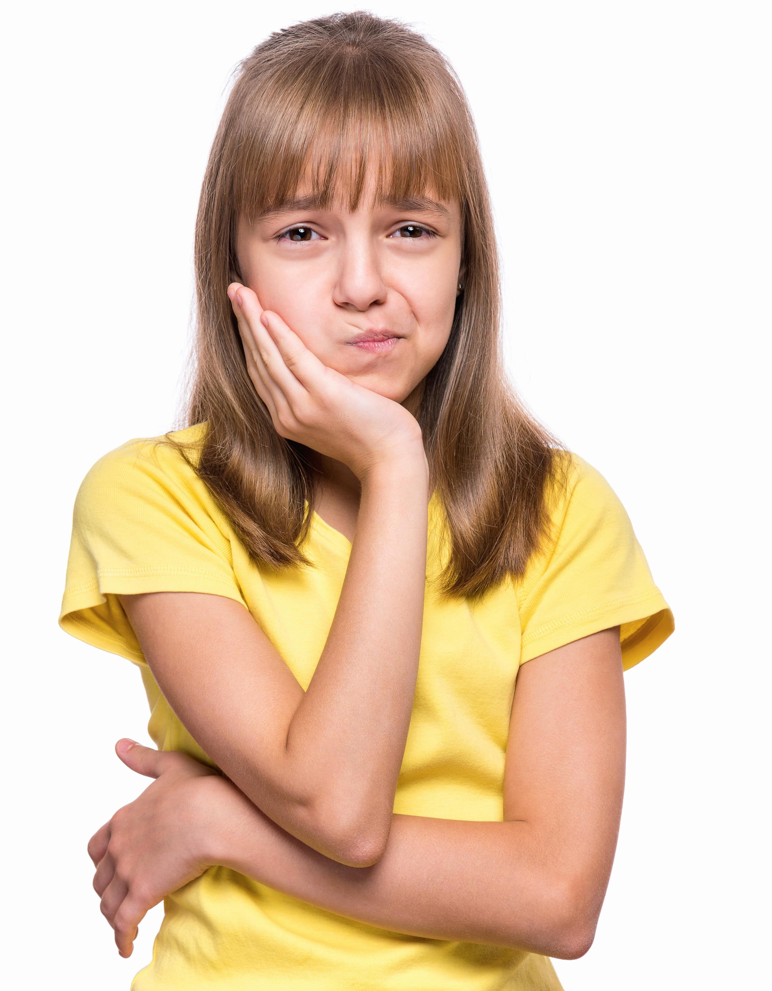 Little girl have toothache, isolated on white background. Emotional portrait of caucasian girl wearing yellow t-shirt. Sad child with tooth pain. Dental problem - kid suffering from toothache.