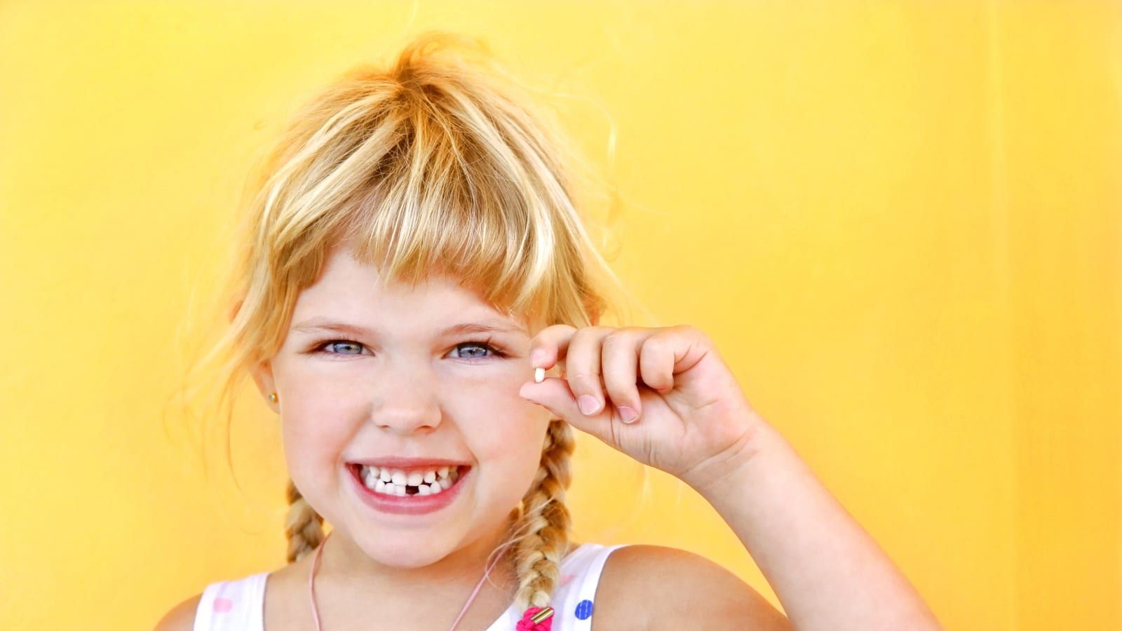 Child holding a baby tooth